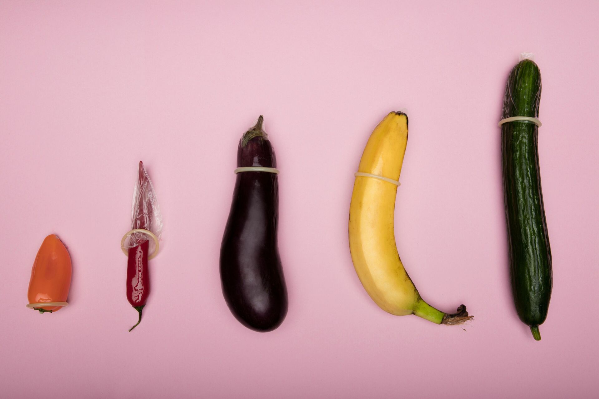 Diverse Früchte und Gemüse mit Kondom