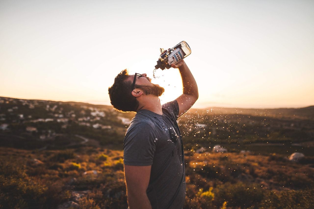 Mann trinkt viel Wasser aus Flasche