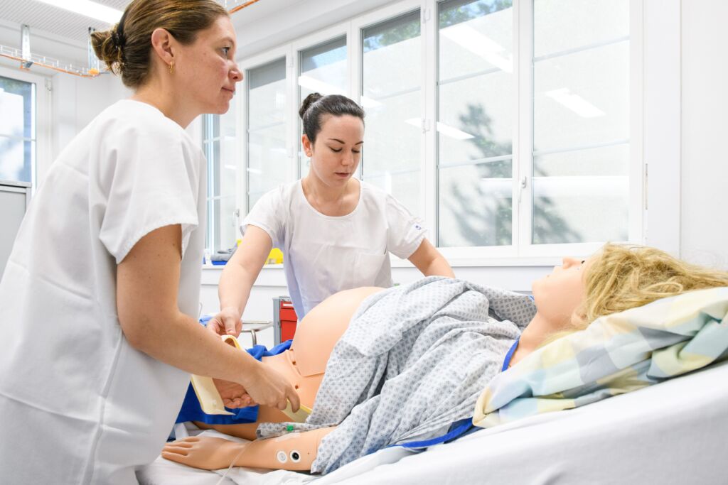 Hebammen in Ausbildung üben an Dummy