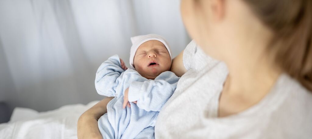 Neugeborenes Babys schläft im Arm der Mutter