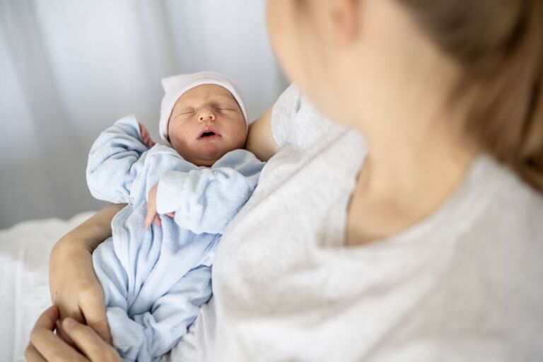 Neugeborenes Babys schläft im Arm der Mutter