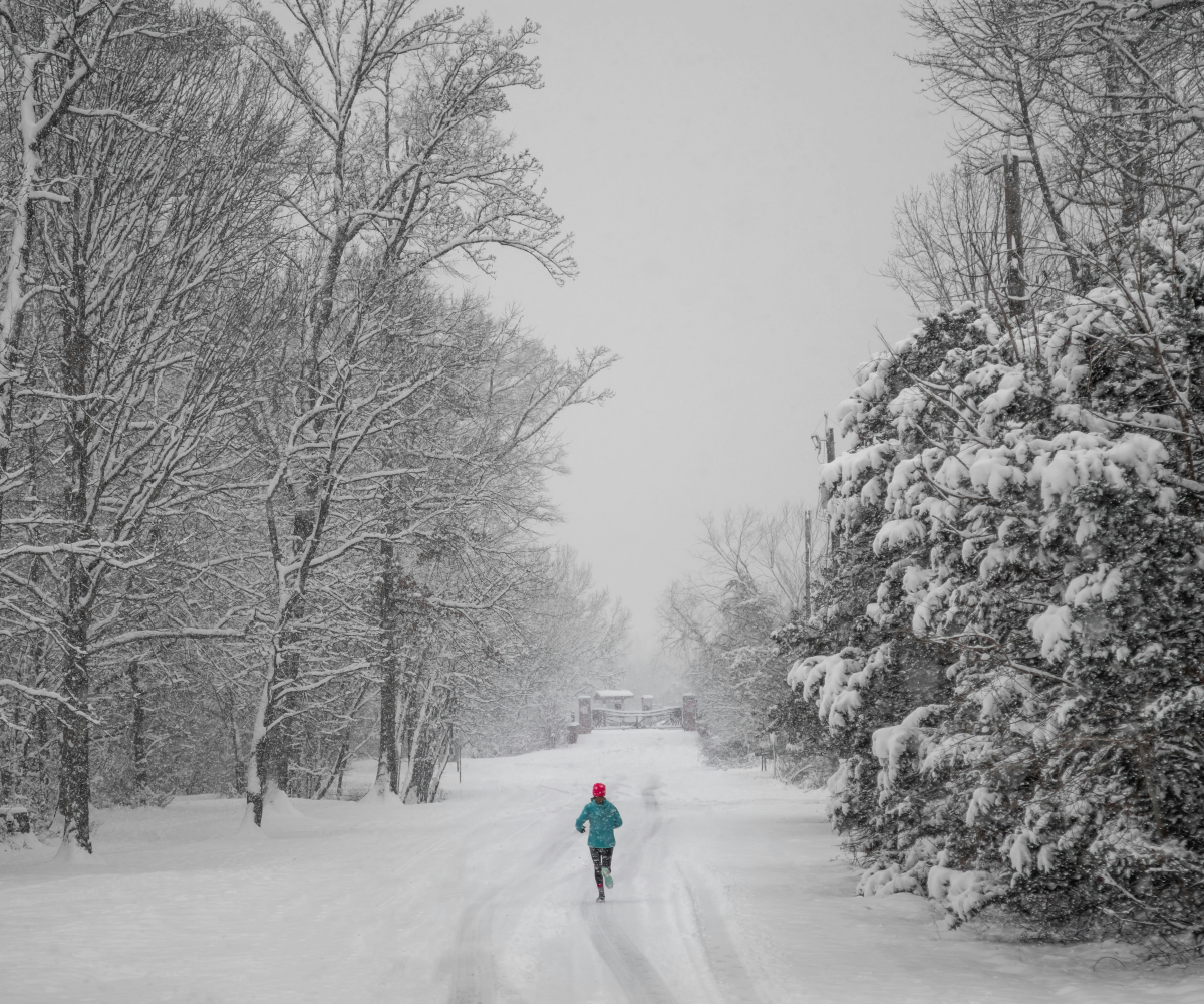 Sportler joggt in verschneiter Winterlandschaft